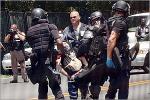 A young protester is carried away by unmarked robocops