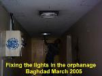 Replacing damaged light fittings. Baghdad March 2005. 