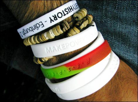 White Make Poverty wrist bands with a new Respect wrist band