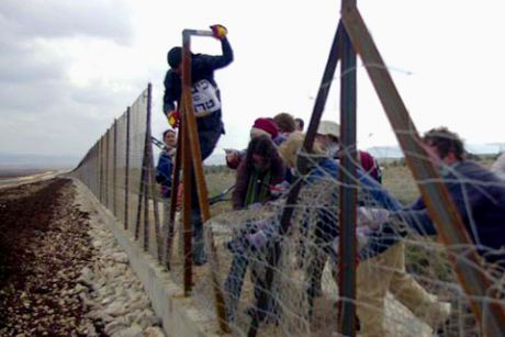activists destroying a section of the wall