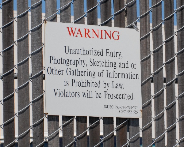 Signs prohibit photography, sketching, and gathering of information