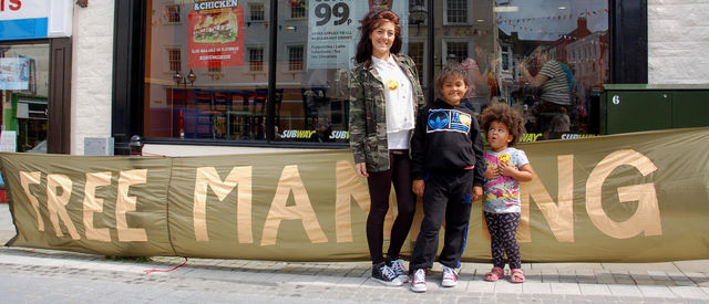 Kids with 'Free Manning' stickers pose for a photo (Castle Square)