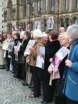 Holding up photos of loved ones who died of the asbestos cancer mesothelioma