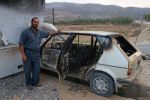 Issam with the remains of his car