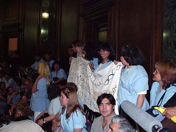 factory workers in the court, holding up a banner