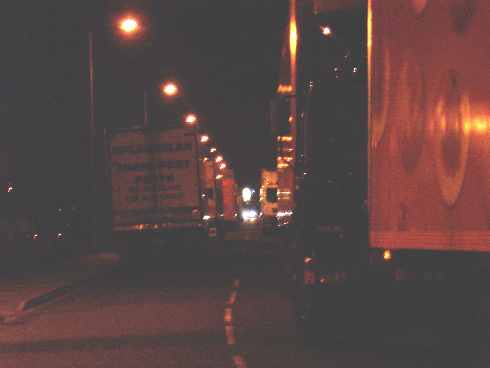 Lorries queuing; light of police car in backround