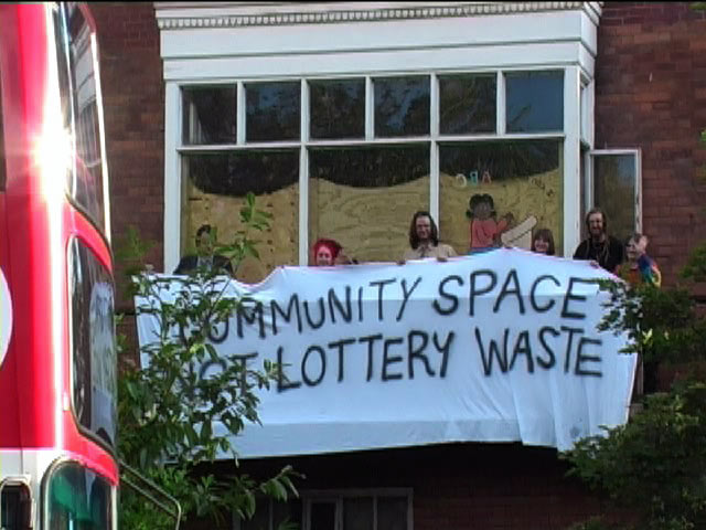 "Community Space or Lottery Waste?" banner on the Social Centre's balcony