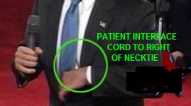 Handheld control is behind necktie.
