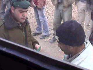 Israeli soldier questions Palestinian.
