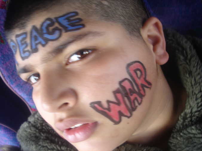 Young Kasim, aged 13, shows off his anti-'war paint' on the coach