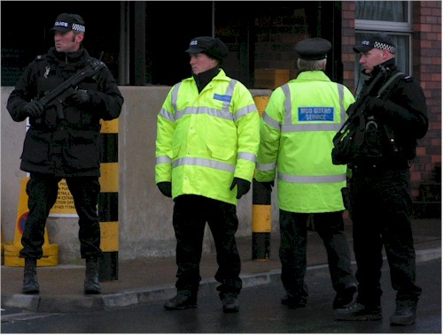 Armed MOD officers look on