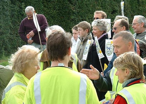 Marshals get organized while the Lib Dem block pose for a photo