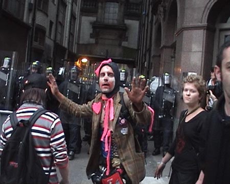 CIRCA Clowns trying to stop people throwing stuff at Police