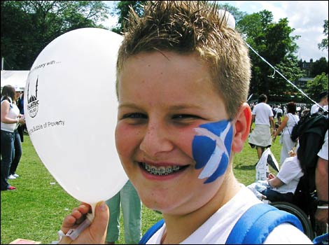 Boy with Scotland flag painted on his face and Make Poverty History balloon