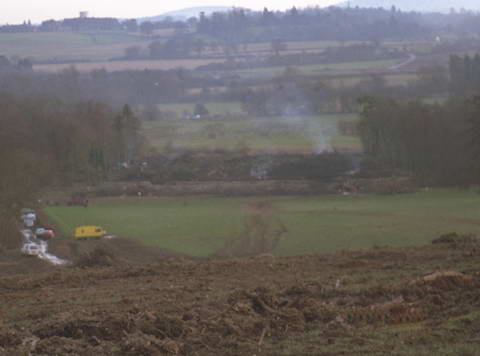 smouldering ruins of the rickety site in near distance then camelot, kennet etc.