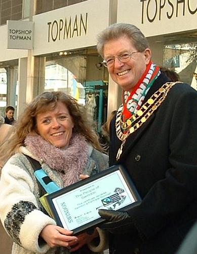 Barbara presents a plaque to the mayor