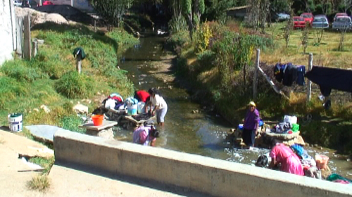 Barrio women and children washing clothes in the river