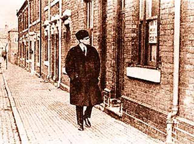Malcolm X walks down Marshall Street in February 1965