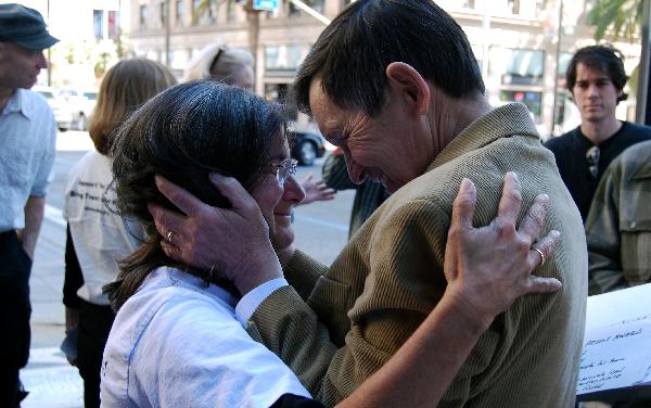 Dennis Kucinich comforts Pat Alviso who has a son in Iraq.