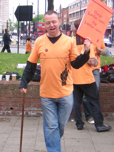 Striker with a t-shirt pointing at the poverty line