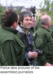 Police take pictures of the assembled journalists