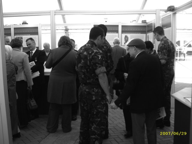 a war veteran chatting with 'new blood' soldiers inside the "we were there" tent