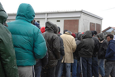 Homeless refugees queue for food