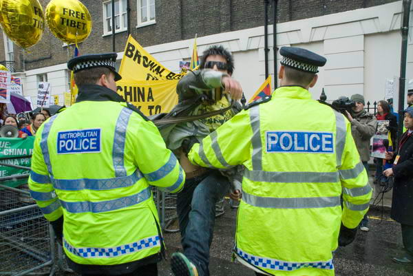 Police guide a demonstrator to the pen