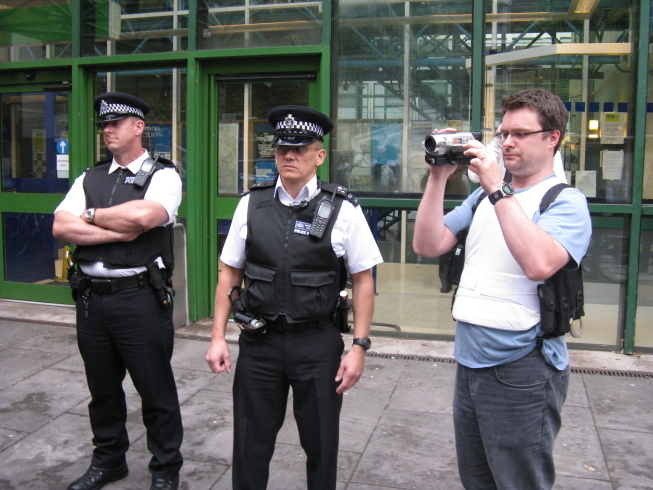 Plain clothed, but none to subtle, police videographer
