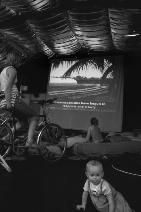 UK, London. Oval. Climate camp caravanners watching cycle-powered cinema.