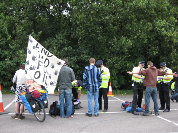 Police search people on their way into the camp