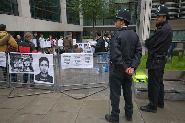 Two police keep an eye on demonstrators and photographers