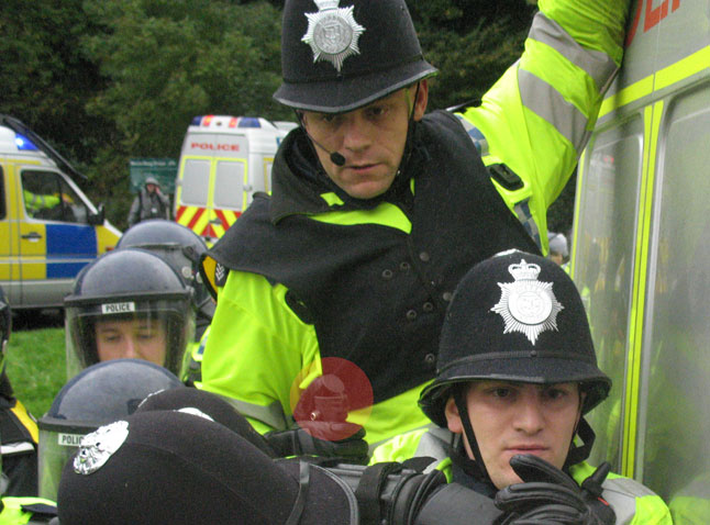 The cop in the background has just off loaded pepper spray