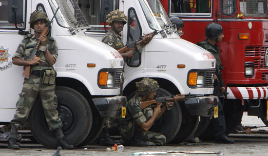 Members of Indian security forces taking up firing positions outsid of Taj Hotel