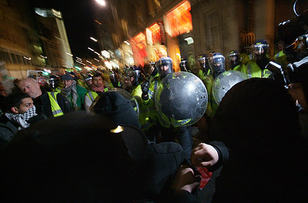 Riot police attempt to control the crowd.