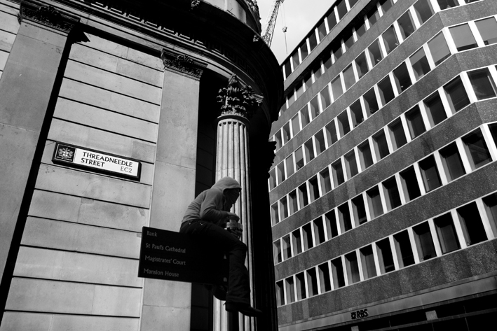 01.04.09 - G20 demonstrations. Demonstrator up lamp-post outside Bank of Eng.