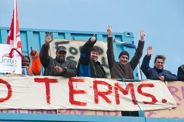 Workers on the rooftop call for Ford Terms