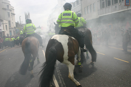 A flare is set off in front of Police horses on London Road