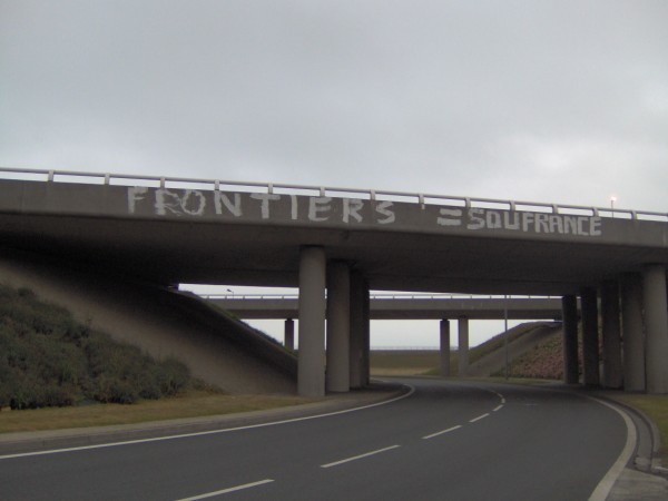 "BORDERS = SUFFERING" at ferry port roundabout