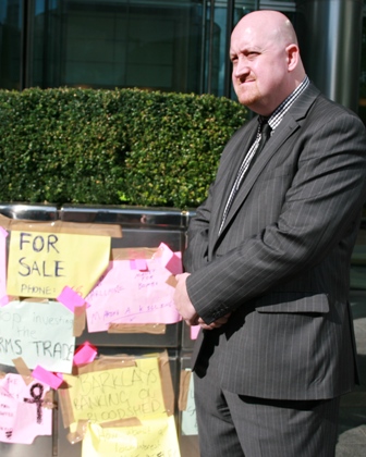Barclays security looks on at messages the protesters left