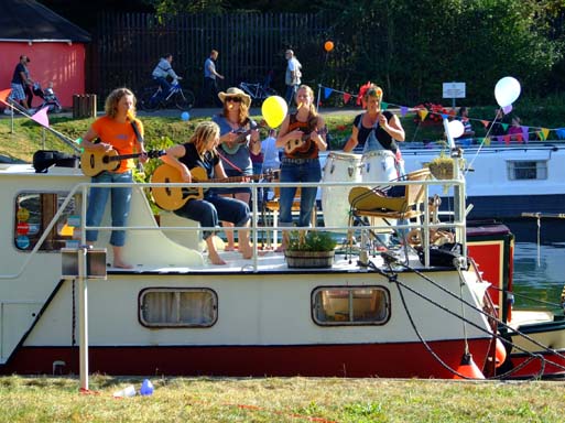A bevvy of boating babes with their kissers around Kazoos.