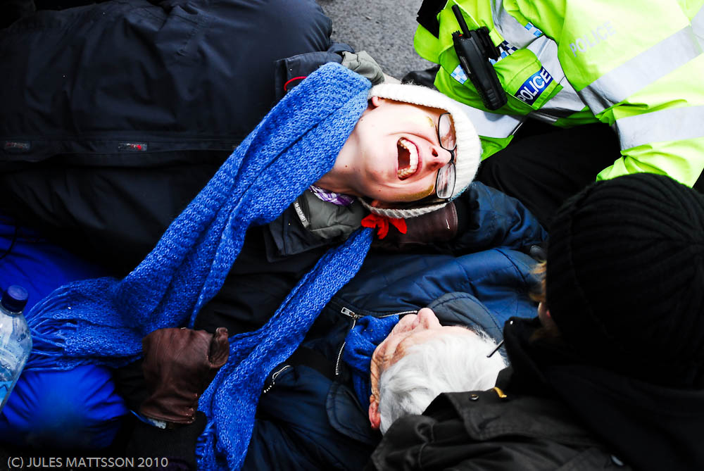 Police attempting to move locked-on blockaders, causing much arm twisting