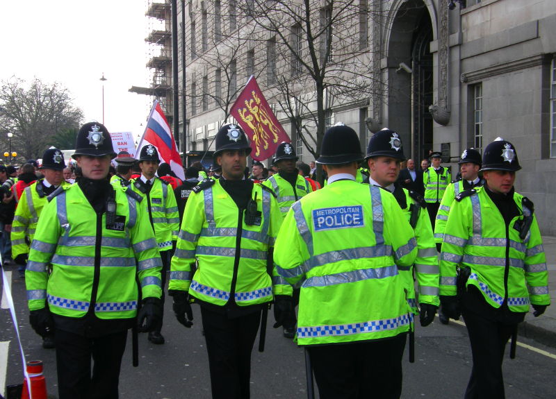 E1. Racists March – Multi-Ethnic Cops Lead The Way (upside MI5 HQ)