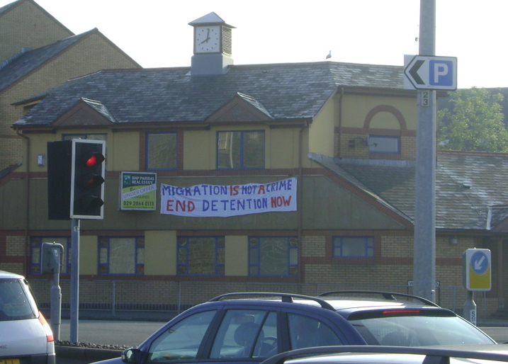 "Migration is not a Crime - End Detention Now" banner opposite Cardiff Prison