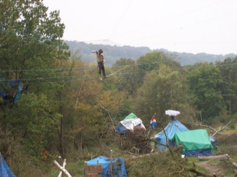 Protester on ropewalk above camp