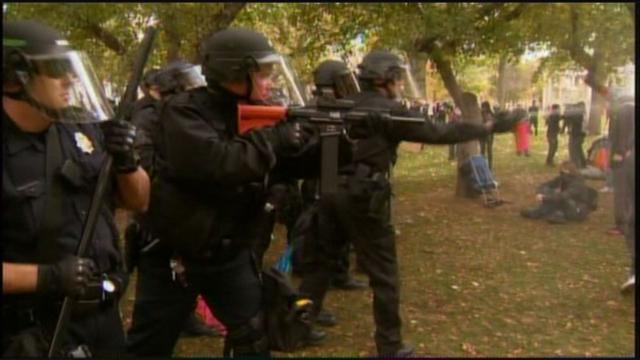 Police pointing "less-than-lethal" weapons at non-violent protestors