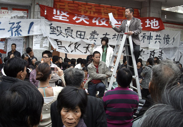 Xue Jinbao addressing a meeting before his death at the hands of the state