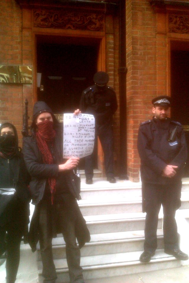 holding up message while police block door of consulate