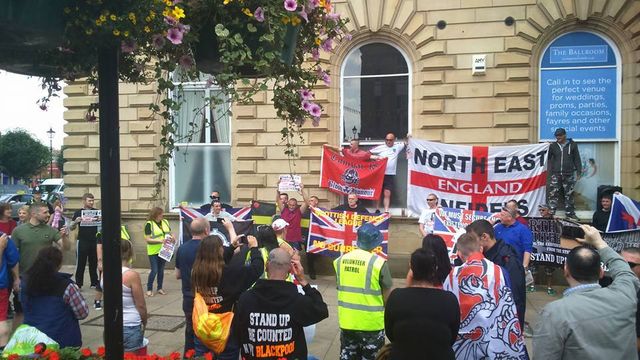 Tony Baker with NEI flag at far-right demo